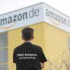 Mit einem T-Shirt mit der Aufschrift "Pro Amazon mit Tarifvertrag" steht ein Beschäftigter des Unternehmens vor dem Logistikzentrum des Versandhauses Amazon in Leipzig.