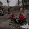 Zwei Techniker sitzen auf einer Straße in Butscha. Hunderte von vermeintlichen Zivilisten sind hier umgekommen.