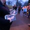 Eine Frau hält Flyer mit einem Bild von Lisa Marie Presley, während Menschen an ihr vorbeigehen, um in Graceland an einem Gedenkgottesdienst teilzunehmen.