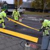 Arbeiter bringen die provisorische Fahrbahnmarkierung in der Einsteinstraße an.  	