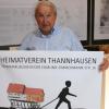 Vorsitzender Manfred Göttner im Festsaal des Heimatmuseums Thannhausen mit dem Plakat zur Ausstellung des Heimatvereins. 	