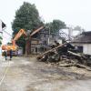 Die Aufräumarbeiten haben in Hollenbach am abgebrannten Stadel begonnen. Aber immer wieder flackern in den Trümmern Flammen auf.