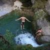 Zwei junge Frauen springen in den Buchenegger Wasserfällen von einem Felsen in eine zehn Meter tiefer gelegene Gumpe.