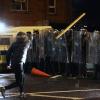 Ein Mann wirft in Nordirland einen Gegenstand in Richtung der Polizisten.