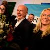 CDU-Spitzenkandidat Kai Wegner steht mit einem Blumenstrauß auf der Bühne der CDU-Wahlparty.