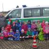 Stolz posieren die Kindergartenkinder vor dem Feuerwehrauto. 	