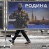 Ein Mann geht in Moskau an einem Plakat mit dem Bild eines russischen Soldaten und der Aufschrift "Wir verteidigen das Vaterland" vorbei .