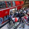 Reisende, zum Teil mit Fahrrädern, wollen am Berliner Hauptbahnhof in einen Regionalzug nach Rostock steigen.