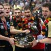 Nach dem Sieg gegen Polen stand Handball-Deutschland Kopf: Trainer Heiner Brand hält den WM-Pokal zusammen mit seinen Spielern Michael Kraus, Torwart Henning Fritz und Kapitän Markus Bauer (von rechts).