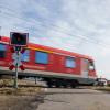 Eine Regionalbahn fährt über einen unbeschrankten Bahnübergang.