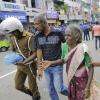 Eine ältere Frau wird in der Nähe des Explosionsort in St. Anthony's Shrine in Colombo gestützt und in Sicherheit gebracht.