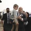 Der israelische Ministerpräsident Naftali Bennett trägt einen Jungen auf dem Arm, der aus der ukrainischen Stadt Schytomyr nach Israel ausgeflogen worden ist.