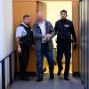 Ein Justizwachtmeister führt den Angeklagten zu Beginn des Prozesses wegen versuchten vierfachen Mordes in den Sitzungssaal des Landgerichts Ulm.