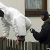 Dieses Archivbild zeigt einen Polizisten (rechts) bei der Tatortbegehung in Gersthofen mit Vanessas Mörder. Michael W. ist mit einem Schutzanzug bekleidet, sein Gesicht ist verhüllt. 