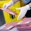 Wahlhelfer bereiten in München die Auszählung der Briefwahl vor.