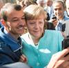 Bundeskanzlerin Angela Merkel (CDU) lässt sich nach dem Besuch einer Erstaufnahmeeinrichtung für Asylbewerber für ein Selfie zusammen mit dem Flüchtling Shaker Kedida aus Mossul (Irak) fotografieren.
