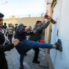 Mit Tritten versuchen Demonstranten, die Tür der US-Botschaft aufzutreten.