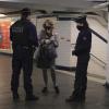 In einer U-Bahn-Station in Paris kontrollieren zwei Polizisten eine Pendlerin. In Frankreich gelten weitreichende Ausgangsbeschränkungen.