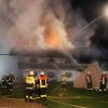 Einsatzkräfte der Feuerwehr kämpfen in Schneizlreuth gegen die Flammen.