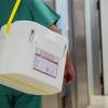 Ein Krankenhausmitarbeiter mit einem Styropor-Behälter zum Transport von zur Transplantation vorgesehenen Organen.