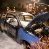 Feuerwehrleute bekämpften die Flammen am brennenden VW Lupo mit Löschschaum. 	