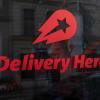 Das Logo und der Schriftzug des Essenslieferdienstes Delivery Hero auf einer Scheibe.