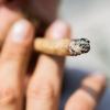 Ein Mann raucht einen Joint. Mit der geplanten Cannabis-Legalisierung sollen auch die Regeln für Cannabis-Konsumenten im Straßenverkehr auf den Prüfstand.