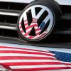 Die US-Fahne spiegelt sich in Logo und Kühlergrill eines Volkswagen-Fahrzeugs.