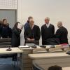 Der Doppelgängerinnen-Mordprozess am Landgericht Ingolstadt. Die Angeklagte hält sich Papier vors Gesicht.