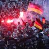 Rechte Demonstranten zünden in Chemnitz Pyrotechnik und schwenken Deutschlandfahnen.