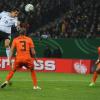 Miroslav Klose (l) köpft vor dem Niederländer John Heitinga (M) zum 2:0 ein. Foto: Jochen Lübke dpa