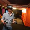 Ein junger Mann taucht mittels einer VR-Brille in eine virtuelle Welt ein.