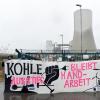 Aktivisten stehen mit einem Transparent vor dem Kraftwerk.