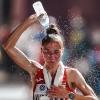 Die hohen Temperaturen in Katar bringen auch Top-Sportler an ihre Grenzen. Hier kippt sich Svetlana Kudzelich aus Weißrussland während des Marathons eine Wasserflasche über den Kopf. 	