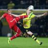 Münchens Jerome Boateng (links) kämpft gegen den Dortmunder Marco Reus um den Ball. Foto: Friso/dpa