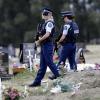 Bewaffnete Polizisten patrouillieren in der Nähe von muslimischen Gräbern auf einem Friedhof in Christchurch.