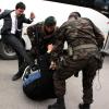 Erdogan-Berater Yusuf Yerkel (l.) tritt einen Demonstranten zusammen, der von zwei Polizisten festgehalten wird.
