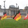 Jahrestag der Erstürmung des Reichstagsgebäudes: Fahnen stehen heute bei einer rechtsextremen Kundgebung vor dem Reichstagsgebäude.