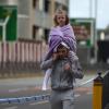 Der abgesperrte Tatort am frühen Morgen: Ein Mann im Trainingsanzug, das Handy am Ohr, trägt ein kleines Mädchen auf seinen Schultern.