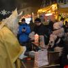 Der Nikolaus teilt vor seinem Postamt Karten an die Kinder aus, die ihm schreiben möchten. 	