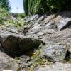 Ein Beispiel für ein Schwammregion-Projekt: Die Regenrinne einer Straße ist mit losem Steinen gesichert, so dass Regenwasser dort versickern kann. So wird versucht, dass das Regenwasser von versiegelten Flächen möglichst nah im Grundboden versickert, wo es wie von einem Schwamm aufgesaugt wird.  