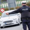 Ein Beamter der Bundespolizei stoppt bei der Kontrolle des Einreiseverkehrs ein Auto.