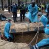 Ukrainische Rettungskräfte bergen bei der Exhumierung in Isjum einen Sarg.