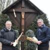 Wolfgang Ebner (links) und Jürgen Schmidt halten erschüttert Trümmer der Jesusfigur am Feldkreuz der Berg- und Wanderfreunde Untermeitingen.