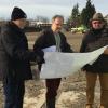 Anton Wolff, Peter Sterz und Stefan Oberschmid (von links) sehen sich die Pläne für den Bau des Hybridrasenplatzes an. 	