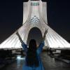 Proteste im Iran: Ein Mädchen steht ohne das vorgeschriebene Kopftuch vor dem Azadi-Turm (Freiheitsturm) und zeigt mit beiden Händen das Sieges-Zeichen. 