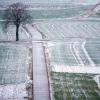 Schnee liegt am Morgen auf Feldern.