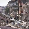 Menschen gehen nach dem Erdbeben im Februar 2023 durch die türkische Stadt Hatay. Bei der Katastrophe starben zehntausende Menschen.