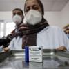 Eine Mitarbeiterin im algerischen  Gesundheitswesen trägt ein Tablett mit einer Packung Ampullen des in Russland hergestellten Corona-Impfstoffs Sputnik V.