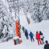 Wintersportler lassen sich von einem Schlepplift einen Skihang hinaufziehen.